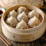 Vegan soup dumplings served in a bamboo steamer.